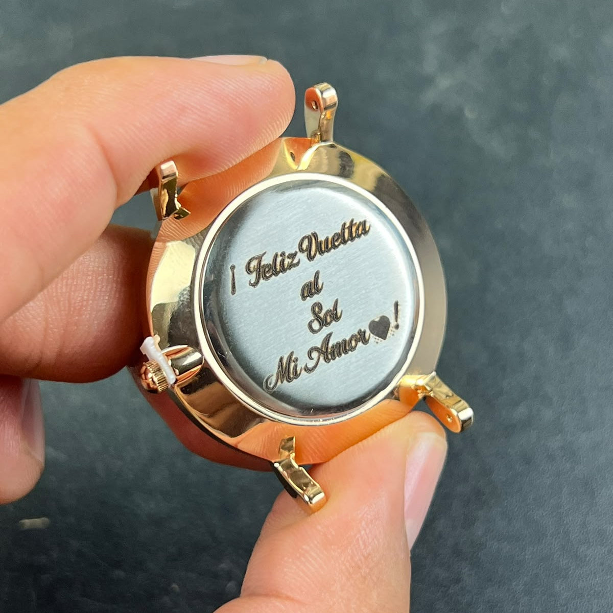 Tapa de reloj dorado con mensaje de cumpleaños personalizado mediante grabado láser.